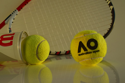 Thumbnail of the edited photo with tennis balls and racquet with warm light from the right side