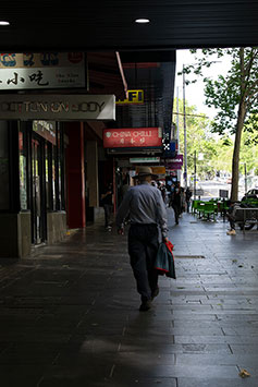 Original photo with a man walking on the street on a dark light and imperfections